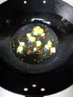 锅内放入足够的油，大火烧热，放入干红辣椒，姜片，蒜瓣，煸炒出香味