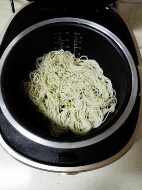 将面条铺在锅内，继续蒸煮6分钟