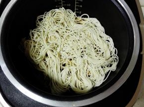 将面条铺在锅内，继续蒸煮6分钟
