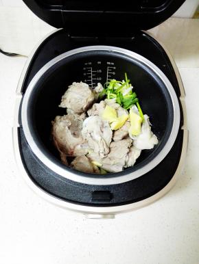 将大骨头放入九阳电饭煲中，放入姜，葱