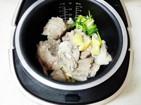 将大骨头放入九阳电饭煲中，放入姜，葱