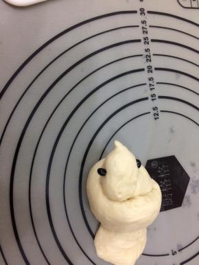 用手轻轻的捏出头部和嘴，用黑豆放在头部两侧，做为眼睛