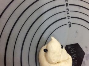 用手轻轻的捏出头部和嘴，用黑豆放在头部两侧，做为眼睛