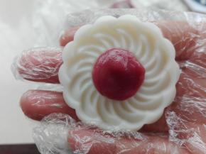 取一个颜色面团放入想要的花色沾点熟糯米粉，按压在模具片间中（如图）