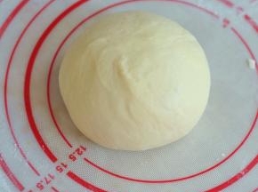 揉成光滑的面团后，取出来滚圆，盖上湿布静置15分钟。