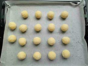 做好的椰蓉球放入铺了油纸的烤盘上