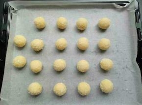 做好的椰蓉球放入铺了油纸的烤盘上