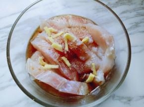 将去皮切丝，把姜丝放进龙利鱼块的模具里。用手抓拌均匀，腌制15分钟。