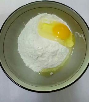 面粉放在碗中，打入鸡蛋，
