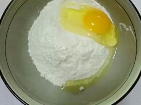 面粉放在碗中，打入鸡蛋，