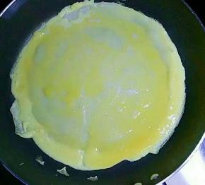 倒入适量打散的鸡蛋液（可直接把鸡蛋打在上面，用勺子摊均匀）