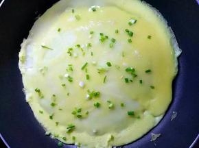 表面撒香葱碎，鸡蛋液凝固后翻面