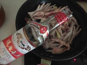 再将鸡爪放入锅中，加适量清水没过鸡爪，倒入30ml白酒，放入姜片