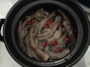 将鸡爪从冰水中捞出，与切成圈的红辣椒一同放入装有糖醋汁的砂锅煲中或玻璃容器里