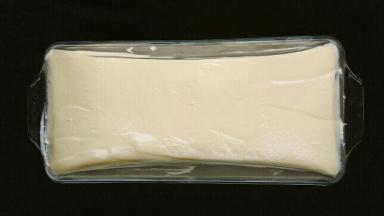 将面糊倒入法焙客磅蛋糕玻璃模具中，震掉大的气泡后用刮刀将面糊弄成中间低、两端稍高的样子，这样有助于出现美丽的自然裂纹