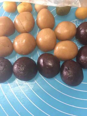 将莲蓉馅和红豆馅分别分成30g的馅。分成16等份，逐个搓圆放着备用。