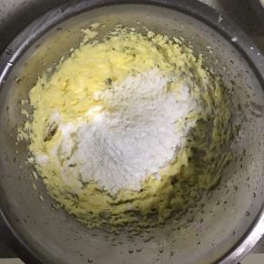 4.筛入一半糖粉及一克盐，用电动打蛋器搅拌至黄油呈现泛白蓬松状态，再筛入剩下的糖粉搅拌至蓬松状态