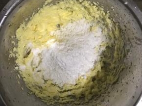 4.筛入一半糖粉及一克盐，用电动打蛋器搅拌至黄油呈现泛白蓬松状态，再筛入剩下的糖粉搅拌至蓬松状态