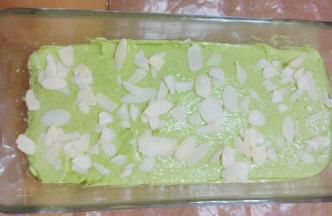 用刮刀将表面抹平，两端高中间稍低，撒上一些杏仁片做装饰。