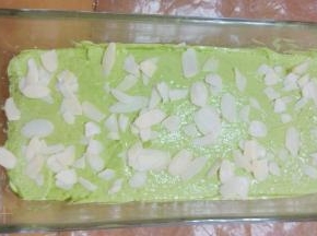 用刮刀将表面抹平，两端高中间稍低，撒上一些杏仁片做装饰。