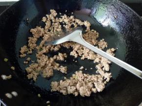 热锅下油，倒入肉末，迅速翻炒至变色。