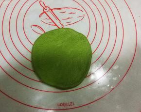 取一绿色面团擀成圆形；