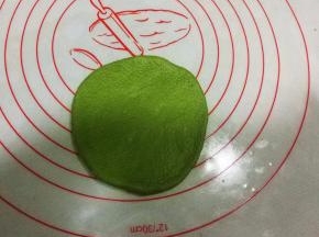 取一绿色面团擀成圆形；