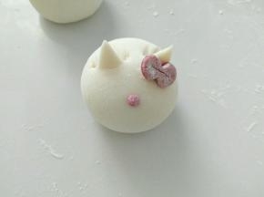贴上蝴蝶结，并贴上红色的鼻子。熟后，画上你喜欢的萌萌哒表情吧！喵喵。。。
