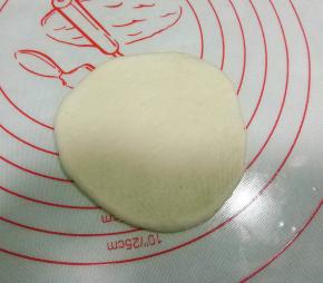 取一白色面团，擀成圆形，尽量中间薄，边缘厚些；