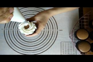 裱花袋与蛋糕呈垂直状态，由外侧向内侧画圈