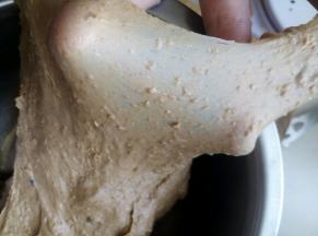 将面团材料混合搅拌均匀揉成光滑面团，加入黄油揉至扩展阶段。能拉出薄膜。