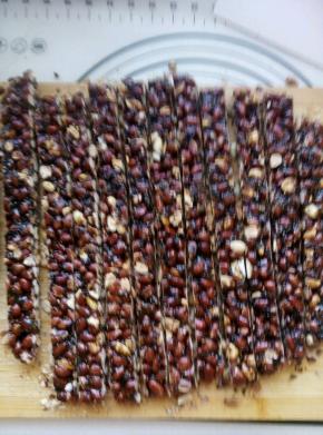 快速的倒入炒熟有些温热的芝麻和花生，搅拌均匀。趁热倒在烤盘。或者案板上。四周大概整成方形。这个步骤有些着急啊 来不及照相 ，下次补上。