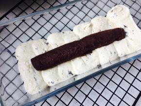 将之前装入裱花袋的黄油糊挤入法焙客玻璃磅蛋糕模具，先挤一层，将甘纳许圆柱放在中间，按压一下，不要太使劲