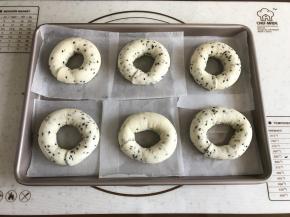 将整完形的面包圈放在油纸上再摆入烤盘。