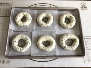 将整完形的面包圈放在油纸上再摆入烤盘。