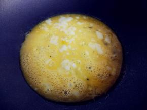 不粘锅中倒入少许油，小火加热。鸡蛋加盐，打散，倒入晃匀