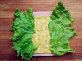 再将切得大小合适的鸡蛋饼和生菜叶放在上面。生菜的多少可根据个人喜好酌情增减