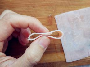 将火腿片切成细条，取一条搭成如图的形状