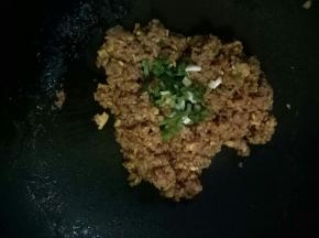 加入调料汁，不断的翻炒，使米饭粒上都裹上酱油汁，炒干，最后撒上葱花，加入鸡精，翻炒均匀即可