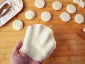 将饧过的面团揉长条，切成大小相当的剂子，擀成中间稍厚，四周尽量薄的薄片