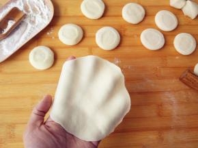 将饧过的面团揉长条，切成大小相当的剂子，擀成中间稍厚，四周尽量薄的薄片