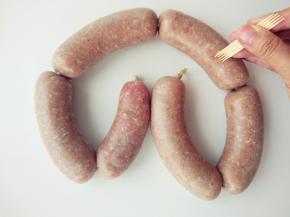 用香肠锥或牙签在表面扎一些孔，这样煮的时候不会涨破。捏住香肠两端，像摇绳一样，第一段超前转动两三圈，第二段向后转动两三圈，并且把肉馅稍往中间推动紧凑，尾端打结