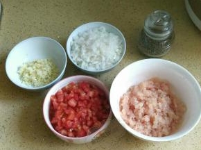 1.将番茄、洋葱和大蒜洗净，去皮，分别切碎；鸡肉洗净切碎，放入碗中。