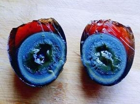 小心的把皮蛋对切开，一切二，(可以把刀沾一些水，这样比较好切，不容易沾刀。)