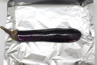 茄子洗净，用厨房纸擦干表面的水份，烤盘垫上锡纸，把茄子放在烤盘中刷上油