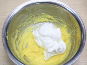 取三分之一打发好的蛋清加入到蛋黄糊中，稍稍搅拌均匀即可，以免消泡。