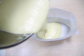 将完全混合均匀的蛋糕糊，倒入垫有油纸的模具