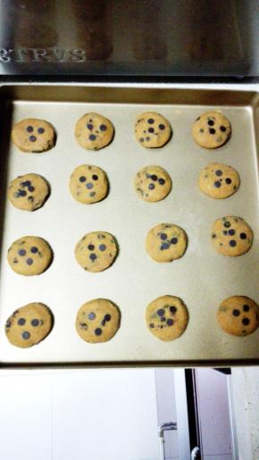 此时烤箱180度，上下管预热
用手搓圆，在手心上按扁成小圆饼状，放在烤盘上，在每个饼城的中心按上三颗巧克力豆装饰