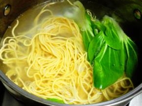 放入胡萝卜面条和洗净的青菜