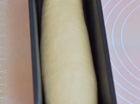 将面团封口朝下，放入土司盒中。